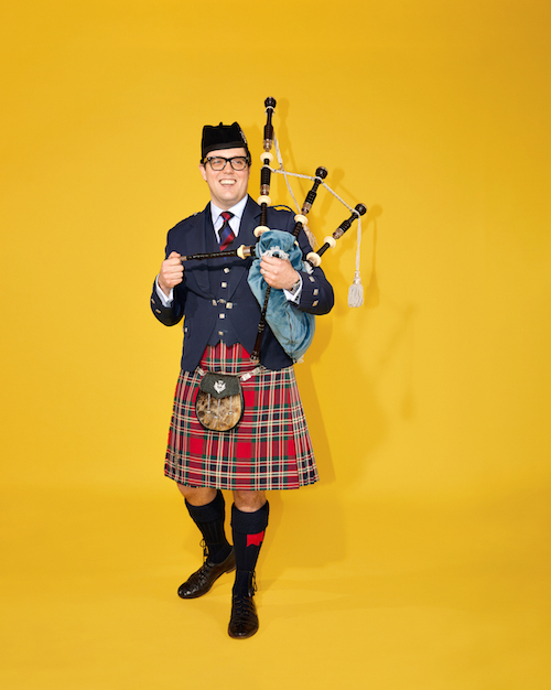 Lionel Tupman smiling and holding bagpipes