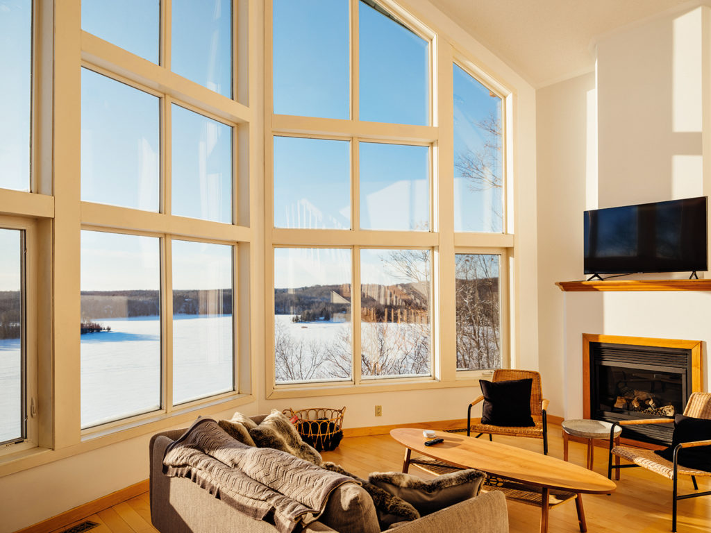 Large windows in the living space of Lindsay Charles and Nick Todorovic's cottage overlooking Wolfe Lake