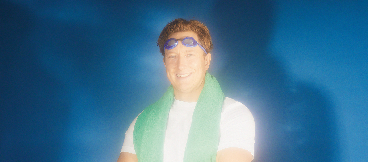 Portrait of Robert McGlashan with googles pulled up on his forehead and a green towel around his neck